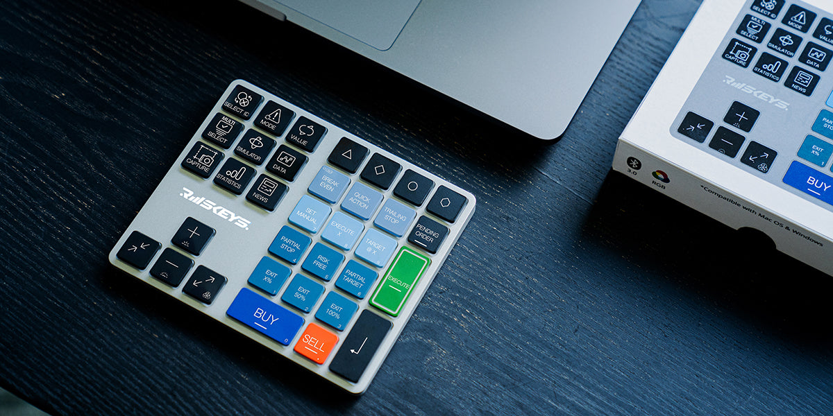 Riskeys Smart Trading Keypad on a desk beside a laptop, designed for efficient trading and statistics management.